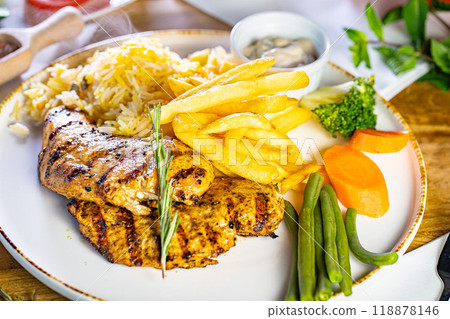 Fried Wiener schnitzel from veal topside with French fries as top view on a modern design plate with copy space Fried Wiener schnitzel from veal topside with French fries as top view on a modern design plate with copy space 118878146