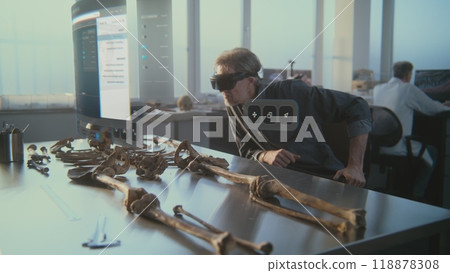 Archaeologist in VR headset studies ancient skeleton using augmented reality 118878308