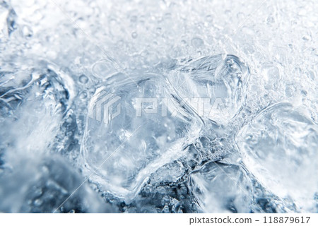 Close up of ice cubes melting in clear water with bubbles and reflections in bright light 118879617