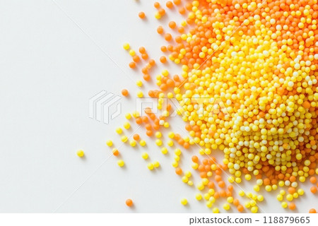Colorful beads scattered on a white surface create a vibrant artistic display for crafting enthusiasts 118879665