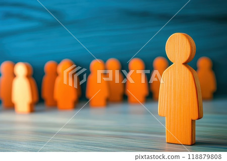 Wooden figures in an orange hue representing community and individuality against a blue background during a creative workshop 118879808