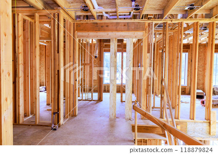 Beam is supported by wooden stud timber framing in interior of newly constructed house. 118879824