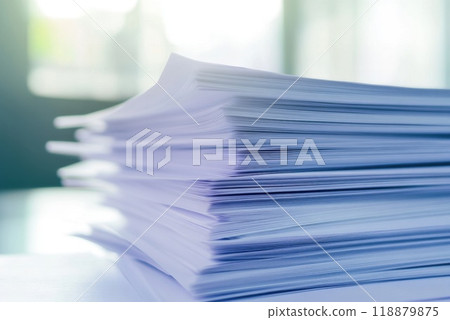 Stacks of neatly organized papers on a table in an office illuminated by natural light in the afternoon 118879875