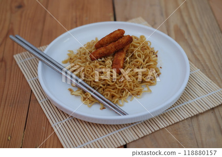 A plate of noodles topped with nugget, creating a delicious and colorful meal. A plate of noodles topped with nugget, creating a delicious and colorful meal. 118880157