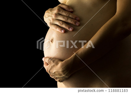 Shadowy portrait of the belly of a pregnant woman Shadowy portrait of the belly of a pregnant woman 118881183