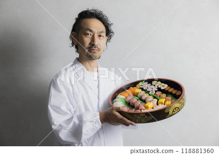 A man in a white coat holding a sushi tub A man in a white coat holding a sushi tub 118881360