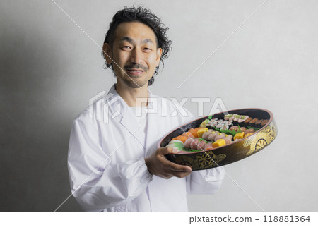 A man in a white coat holding a sushi tub A man in a white coat holding a sushi tub 118881364