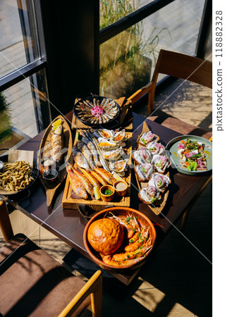 Seafood spread on restaurant table with assorted grilled fish, oysters, prawns, and appetizers Seafood spread on restaurant table with assorted grilled fish, oysters, prawns, and appetizers 118882328