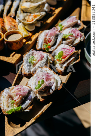 Open-faced sandwiches with herring, cream cheese, pickled onions, and herbs on rye bread Open-faced sandwiches with herring, cream cheese, pickled onions, and herbs on rye bread 118882341