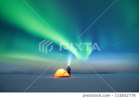 Tourist with flashlight near yellow tent Tourist with flashlight near yellow tent 118882776