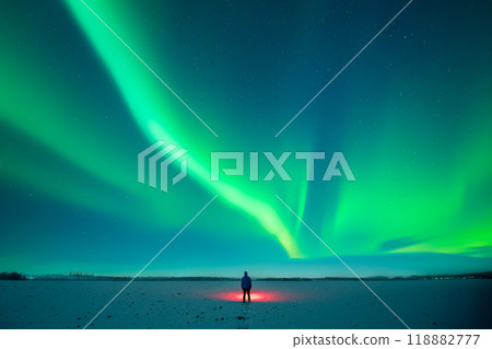 Tourist with red flashlight standing on snowy field Tourist with red flashlight standing on snowy field 118882777