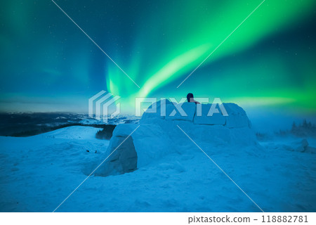 Wintry scene with glowing polar lights and snowy igloo 118882781