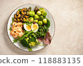 Shrimp and mussels cooked in coconut oil, served with greens, brussels sprouts, broccoli and eggs. Keto diet. 118883135