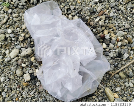 White plastic bag lying on sandstone, Used white plastic bags, plastic trash White plastic bag lying on sandstone, Used white plastic bags, plastic trash 118883159