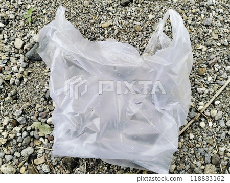 White plastic bag lying on sandstone, Used white plastic bags, plastic trash White plastic bag lying on sandstone, Used white plastic bags, plastic trash 118883162