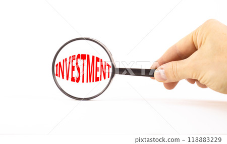 Investment symbol. Concept word Investment in beautiful magnifying glass. Beautiful white paper background. Businessman hand. Business investment concept. Copy space. 118883229