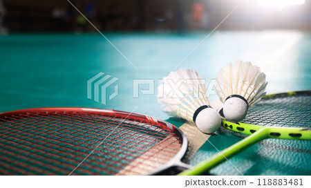 White badminton shuttlecocks and badminton rackets on green floor indoor badminton court. Concept for badminton competition and its lovers. 118883481