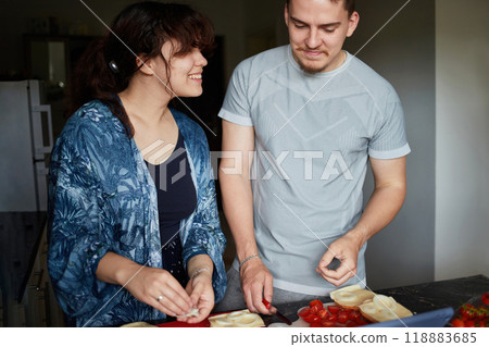 A young couple cooks food together at home using a tablet. 118883685