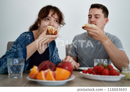 A young couple enjoys food at home. 118883693