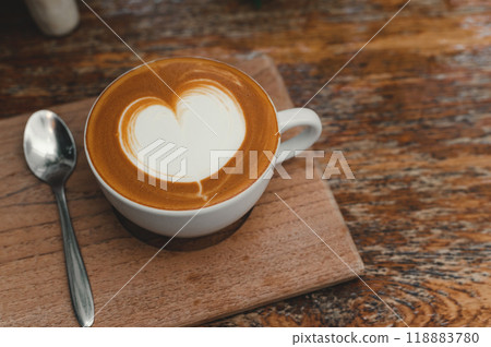 Top view of Hot coffee in white cup with coffee spoon on wooden tray. Copy space. 118883780