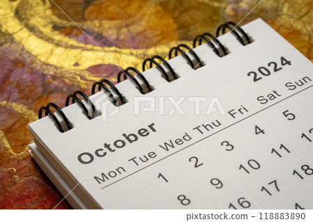 October 2024 - small spiral desktop calendar against abstract marbled paper, time and business concept 118883890