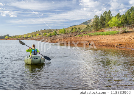 senior male is paddling an inflatable packraft on Horsetooth Reservoir in Colorado 118883903