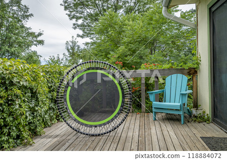 mini trampoline for fitness exercising and rebounding in a backyard patio, summer scenery mini trampoline for fitness exercising and rebounding in a backyard patio, summer scenery 118884072