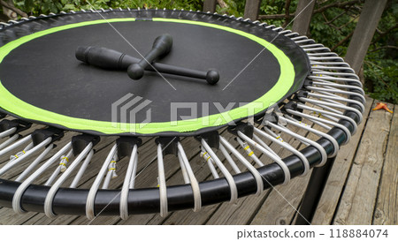mini trampoline with a pair of Indian clubs for fitness exercising and rebounding in a backyard patio mini trampoline with a pair of Indian clubs for fitness exercising and rebounding in a backyard patio 118884074