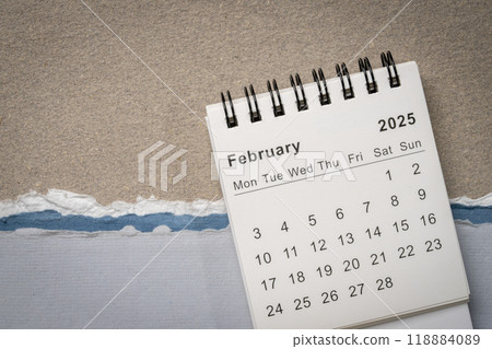 February 2025 - small spiral desktop calendar against abstract paper landscape, time and business concept February 2025 - small spiral desktop calendar against abstract paper landscape, time and business concept 118884089