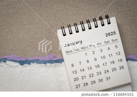 January 2025 - small spiral desktop calendar against abstract paper landscape, time and business concept January 2025 - small spiral desktop calendar against abstract paper landscape, time and business concept 118884101