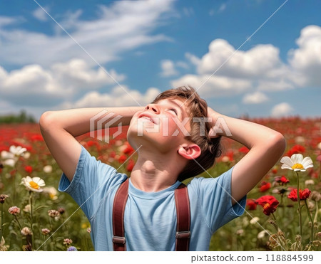 A boy in a field of flowers, looking up at the sky 118884599