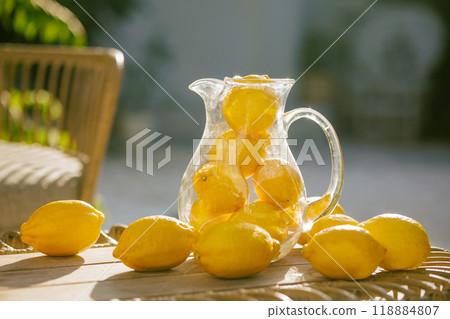 A pitcher of lemonade with sliced lemons and oranges on a table A pitcher of lemonade with sliced lemons and oranges on a table 118884807