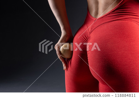 girl doing buttock massage with wooden yoga ball close up, self massage tool 118884811