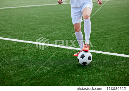 And the soccer player in the uniform and red clothes controlling the soccer ball on the Green Field And the soccer player in the uniform and red clothes controlling the soccer ball on the Green Field 118884815