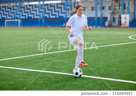 And the soccer player in the uniform and red clothes controlling the soccer ball on the Green Field And the soccer player in the uniform and red clothes controlling the soccer ball on the Green Field 118884841