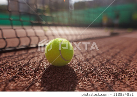 Tennis ball close up against tennis net on court background 118884851