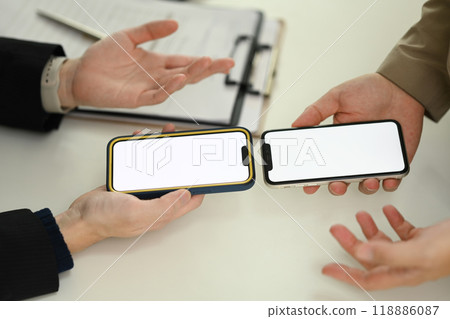 Two young people sharing data between smartphones. Technology, data transfer or collaboration concept Two young people sharing data between smartphones. Technology, data transfer or collaboration concept 118886087