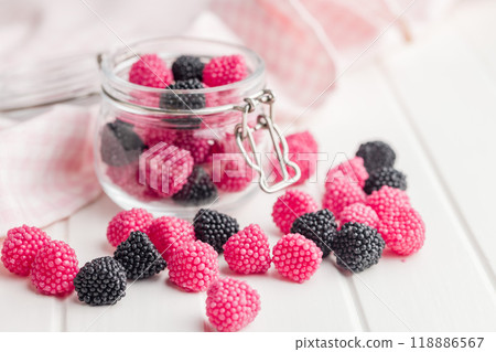 Sweet jelly candies in jar on white table. Sweet jelly candies in jar on white table. 118886567