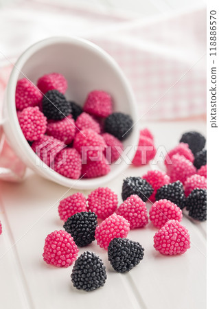 Sweet jelly candies in bowl on white table. Sweet jelly candies in bowl on white table. 118886570