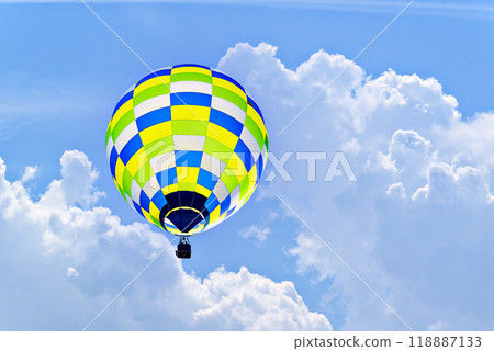 Colorful hot air balloon flying over blue sky with white clouds Colorful hot air balloon flying over blue sky with white clouds 118887133