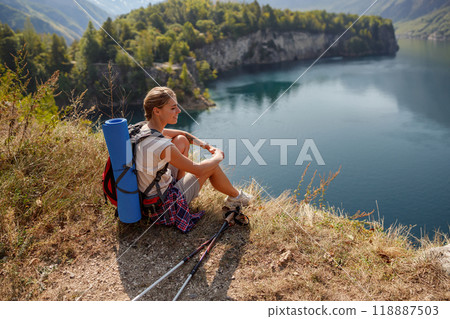 A Hiker Enjoying a Scenic Lake View During a Daytime Adventure in Natures Embrace 118887503