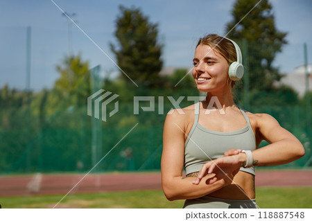 A Young Woman Dressed in Stylish Sportswear Who is Enjoying a Fun Workout Session Outdoors A Young Woman Dressed in Stylish Sportswear Who is Enjoying a Fun Workout Session Outdoors 118887548