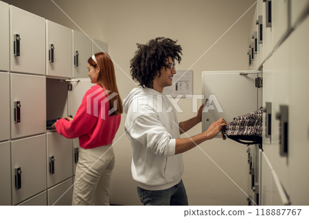 Two young people standing near the lockers and talking Two young people standing near the lockers and talking 118887767