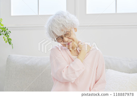 Senior woman with stiff shoulders in living room 118887978