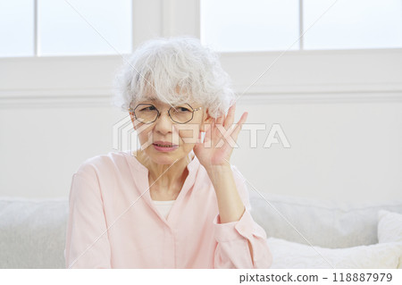 Hearing-impaired senior woman in the living room 118887979