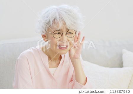 Hearing-impaired senior woman in the living room 118887980
