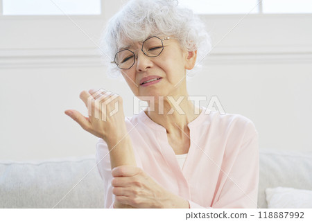 Senior woman with numb hands in living room 118887992