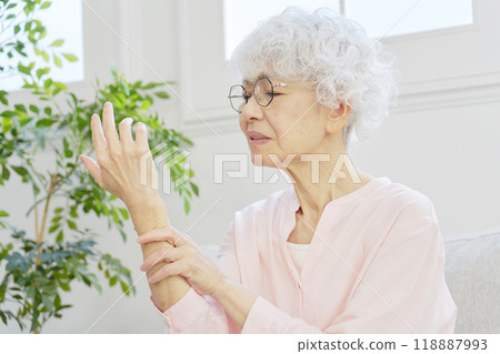 Senior woman with numb hands in living room 118887993