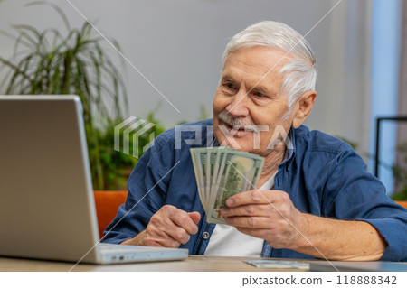 Happy senior man counting money cash and use laptop pc calculate domestic income earnings at home 118888342