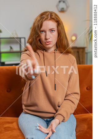 Displeased upset young woman sitting on sofa reacting to unpleasant awful idea, shake finger No Displeased upset young woman sitting on sofa reacting to unpleasant awful idea, shake finger No 118888412